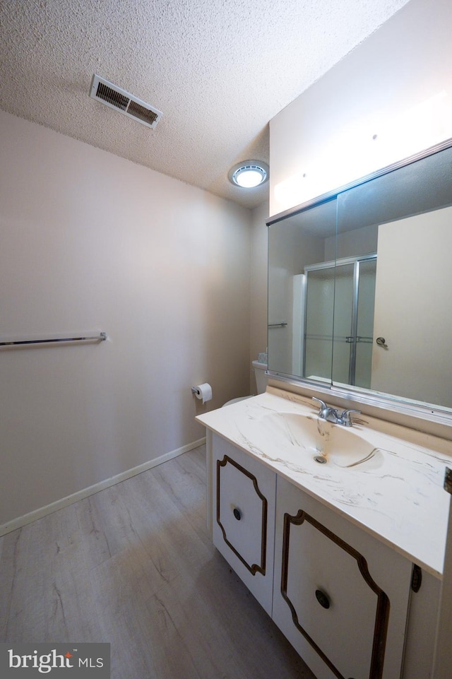 702 Downing Ct, Westampton, NJ 08060 - bathroom featuring wood finished floors, vanity, a textured ceiling, a shower stall, and baseboards
