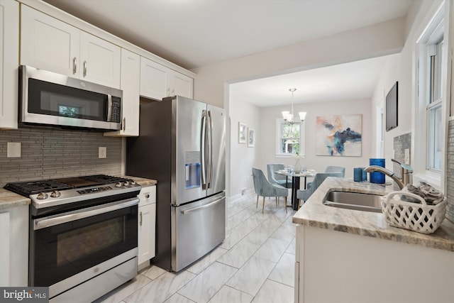 5609 35th Ave, Hyattsville, MD 20782 - kitchen featuring stainless steel appliances, a sink, backsplash, light marble finish floors, and white cabinets
