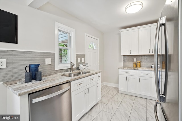 5609 35th Ave, Hyattsville, MD 20782 - kitchen with appliances with stainless steel finishes, a sink, backsplash, and light marble finish flooring
