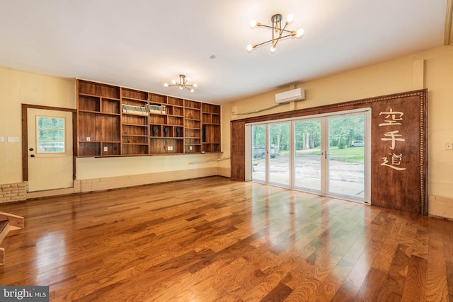9532 Lyons Mill Rd, Owings Mills, MD 21117 - unfurnished living room featuring a chandelier, wood finished floors, an AC wall unit, and built in features
