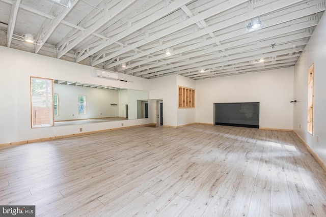 9532 Lyons Mill Rd, Owings Mills, MD 21117 - unfurnished living room with hardwood / wood-style flooring, a wall unit AC, and baseboards
