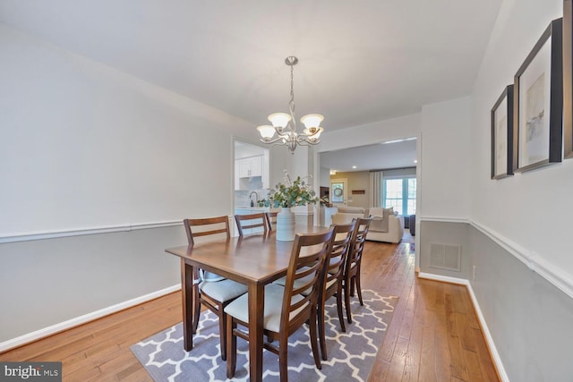 43501 Plantation Ter, Ashburn, VA 20147 - dining room featuring a chandelier, hardwood / wood-style flooring, and baseboards