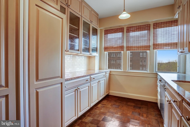 4000 Cathedral Ave NW Unit 517B, Washington, DC 20016 - kitchen featuring glass insert cabinets, light stone counters, decorative backsplash, and decorative light fixtures