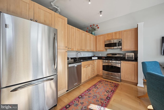 811 4th St NW Unit 720, Washington, DC 20001 - kitchen with appliances with stainless steel finishes, light brown cabinets, a sink, light wood-style flooring, and vaulted ceiling