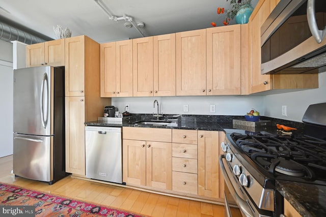 811 4th St NW Unit 720, Washington, DC 20001 - kitchen featuring stainless steel appliances, light brown cabinets, a sink, light wood-type flooring, and dark stone countertops