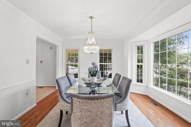 13412 Glen Taylor Ln, Herndon, VA 20171 - dining area featuring a chandelier, plenty of natural light, wood finished floors, and crown molding