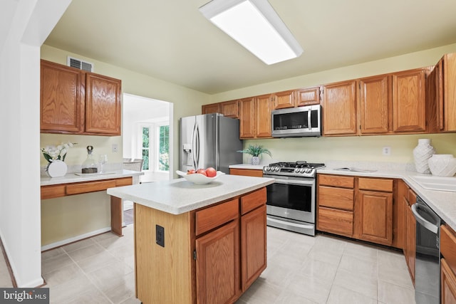 13412 Glen Taylor Ln, Herndon, VA 20171 - kitchen featuring stainless steel appliances, light countertops, light floors, a kitchen island, and brown cabinets