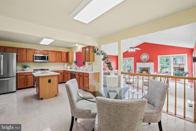 13412 Glen Taylor Ln, Herndon, VA 20171 - dining area with a ceiling fan, a warm lit fireplace, and lofted ceiling