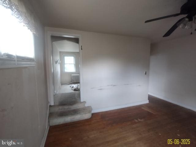 608 Chestnut Hill Ave, Baltimore, MD 21218 - spare room with radiator heating unit, ceiling fan, wood finished floors, and stairs