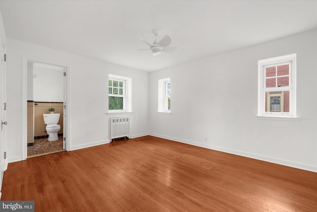 109 W Philadelphia Ave, Boyertown, PA 19512 - unfurnished bedroom featuring radiator, wood finished floors, baseboards, ensuite bath, and a ceiling fan