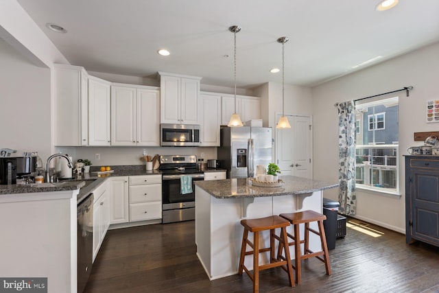 8109 Secluded Cove Ln, Dundalk, MD 21222 - kitchen with appliances with stainless steel finishes, white cabinets, a center island, a breakfast bar area, and recessed lighting
