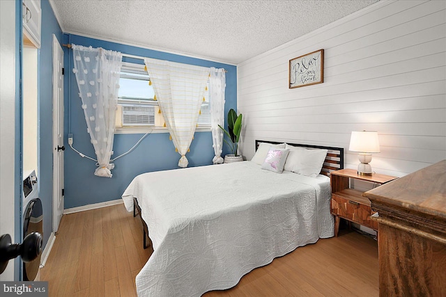 12 72nd St Unit 303, Ocean City, MD 21842 - bedroom featuring wood finished floors, a textured ceiling, baseboards, and wooden walls