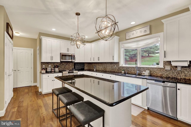 12 Fox Glen Dr, Reading, PA 19608 - kitchen featuring stainless steel appliances, a sink, white cabinets, dark countertops, and a chandelier