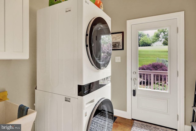 12 Fox Glen Dr, Reading, PA 19608 - laundry area featuring stacked washer and clothes dryer, wood finished floors, and baseboards
