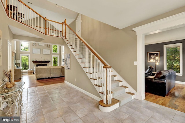 12 Fox Glen Dr, Reading, PA 19608 - staircase featuring baseboards, tile patterned floors, a fireplace, and a high ceiling