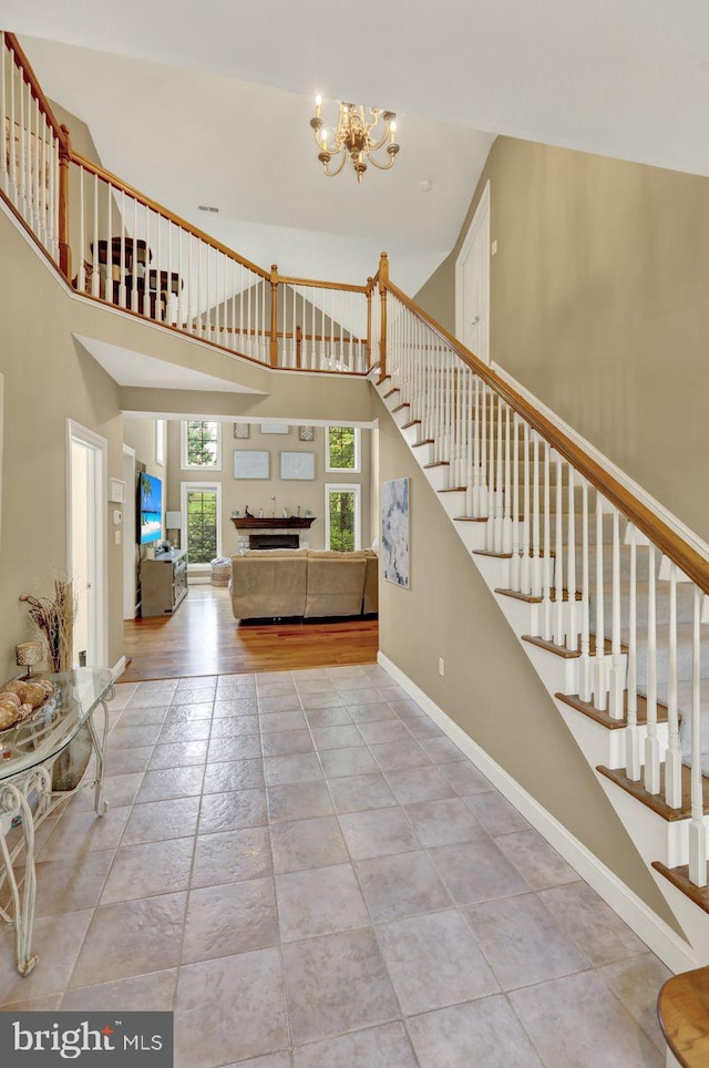12 Fox Glen Dr, Reading, PA 19608 - stairway featuring a chandelier, a fireplace, a high ceiling, and baseboards