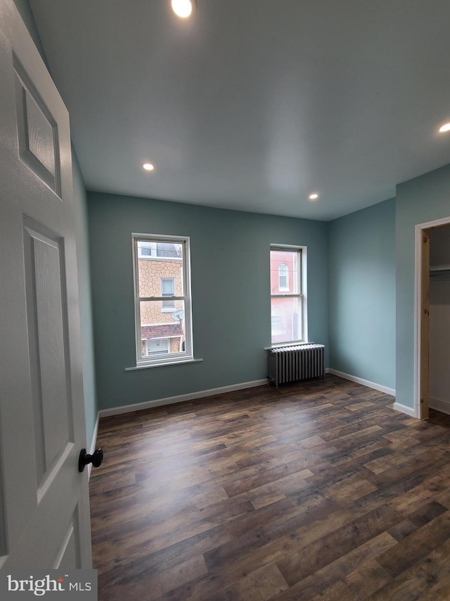 1218 Fidelity St, Reading, PA 19604 - unfurnished bedroom featuring radiator heating unit, dark wood-type flooring, recessed lighting, and baseboards