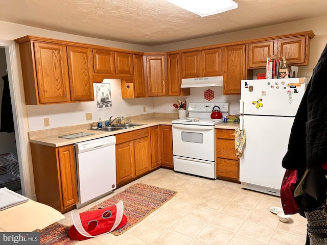 110-112 W Bishop St, Bellefonte, PA 16823 - kitchen with white appliances, under cabinet range hood, a sink, and brown cabinetry