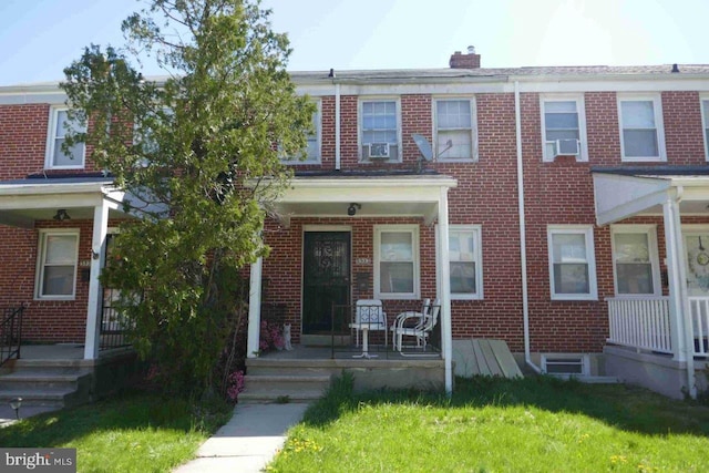5933 Leith Walk, Baltimore, MD 21239 - multi unit property featuring a porch, brick siding, a chimney, and a front lawn