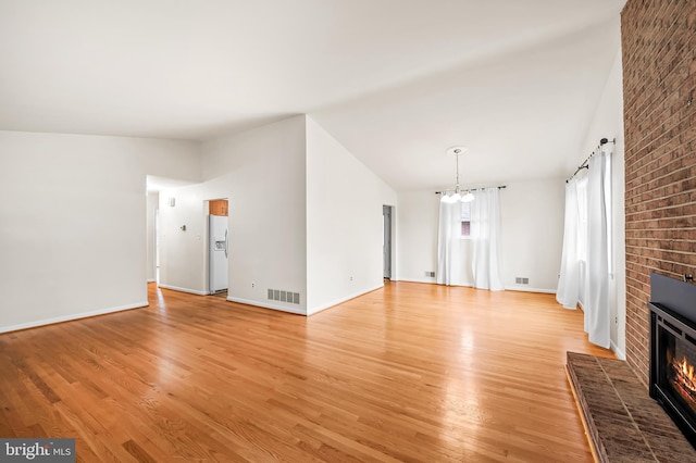 8320 Overmont, Parkville, MD 21234 - unfurnished living room with vaulted ceiling, a chandelier, light wood-style flooring, a fireplace, and baseboards
