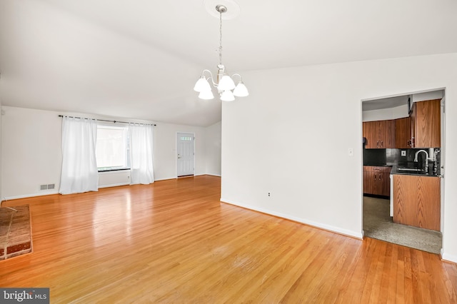 8320 Overmont, Parkville, MD 21234 - unfurnished living room featuring a chandelier, light wood-type flooring, a sink, baseboards, and lofted ceiling