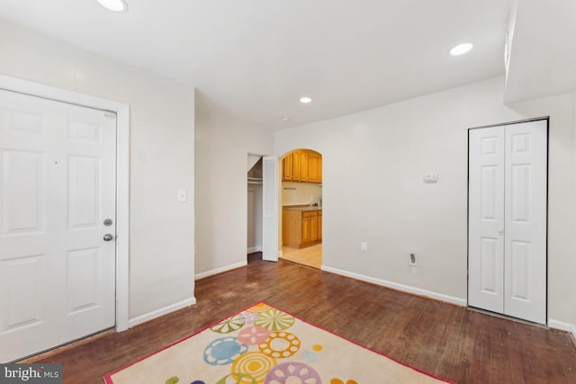 1707 H St NE, Washington, DC 20002 - unfurnished bedroom with arched walkways, dark wood-style flooring, baseboards, recessed lighting, and ensuite bathroom