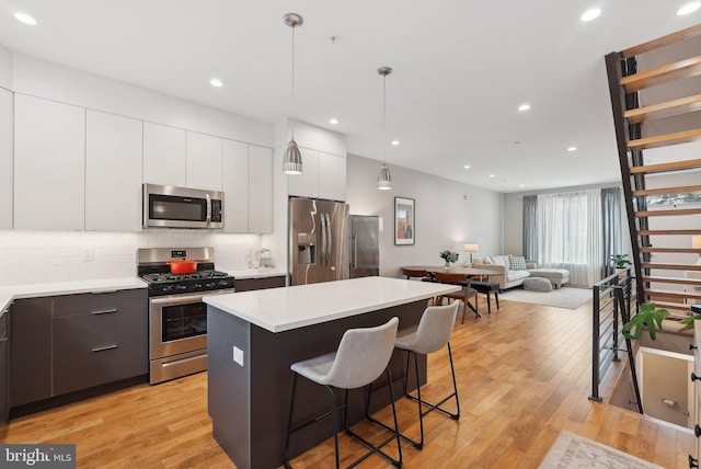 2811 Wharton St, Philadelphia, PA 19146 - kitchen featuring stainless steel appliances, a center island, backsplash, light countertops, and recessed lighting