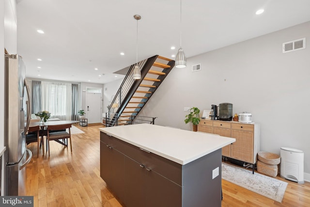 2811 Wharton St, Philadelphia, PA 19146 - kitchen with freestanding refrigerator, a kitchen island, light wood finished floors, light countertops, and decorative light fixtures