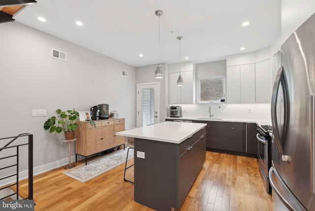 2811 Wharton St, Philadelphia, PA 19146 - kitchen featuring stainless steel appliances, modern cabinets, a sink, a breakfast bar, and white cabinetry
