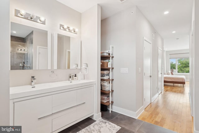 2811 Wharton St, Philadelphia, PA 19146 - ensuite bathroom with double vanity, tiled shower, wood finished floors, baseboards, and recessed lighting