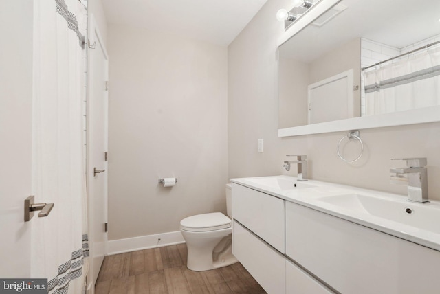 2811 Wharton St, Philadelphia, PA 19146 - bathroom featuring double vanity, toilet, baseboards, and wood finished floors