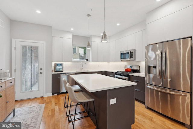 2811 Wharton St, Philadelphia, PA 19146 - kitchen with appliances with stainless steel finishes, a sink, modern cabinets, a kitchen bar, and decorative backsplash
