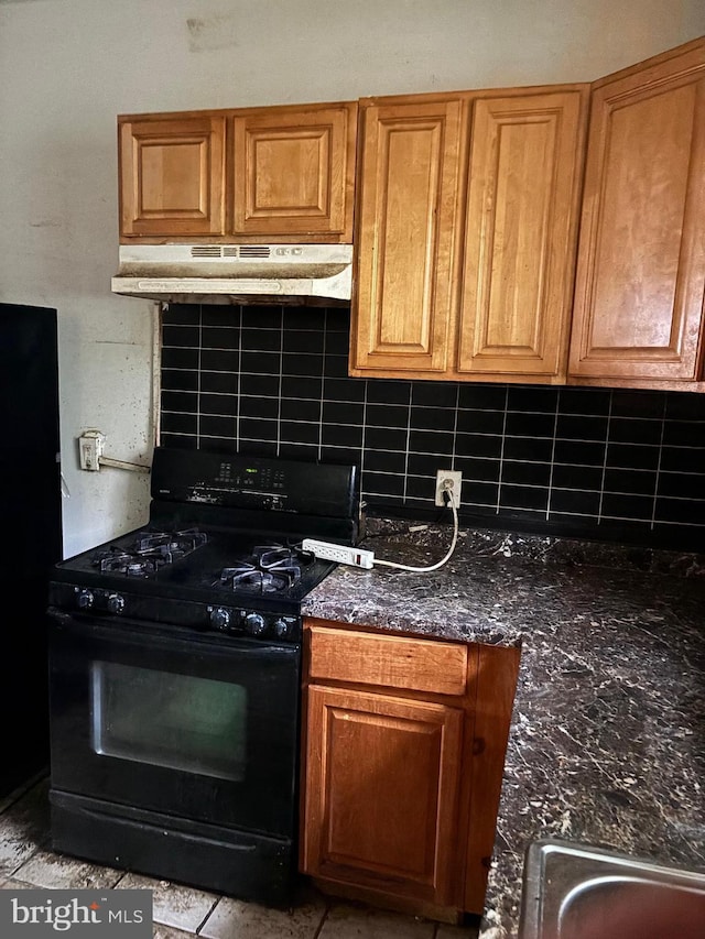 1436 S Etting St, Philadelphia, PA 19146 - kitchen with black range with gas cooktop, under cabinet range hood, backsplash, and brown cabinetry