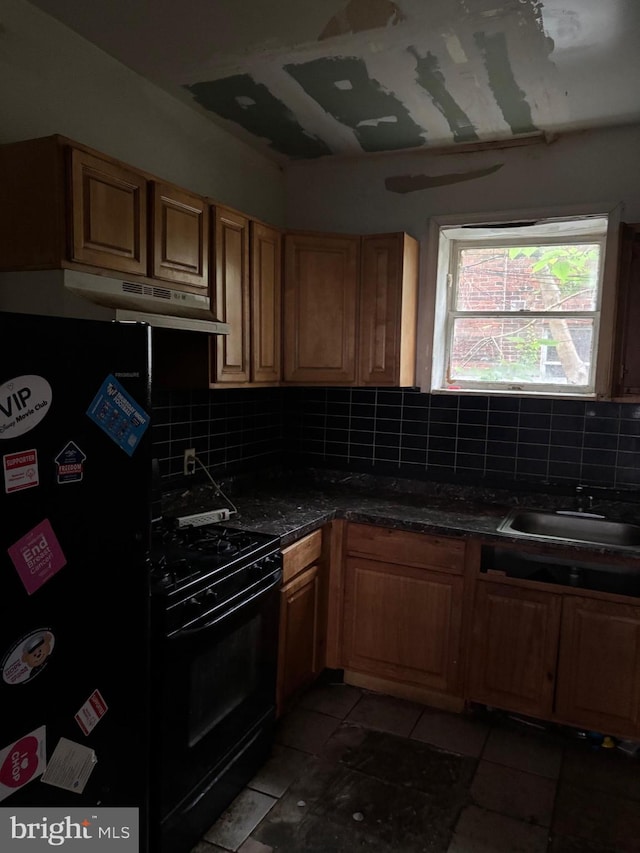 1436 S Etting St, Philadelphia, PA 19146 - kitchen featuring a sink, black appliances, decorative backsplash, light tile patterned flooring, and dark countertops