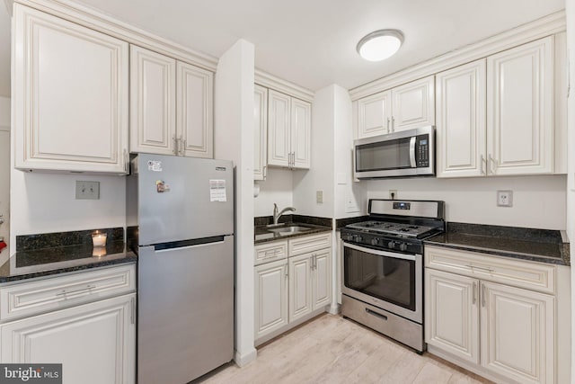 801 N Pitt St Unit 505, Alexandria, VA 22314 - kitchen with stainless steel appliances, a sink, light wood-type flooring, and dark stone counters