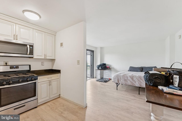 801 N Pitt St Unit 505, Alexandria, VA 22314 - kitchen featuring stainless steel appliances, light wood-style floors, open floor plan, dark countertops, and baseboards