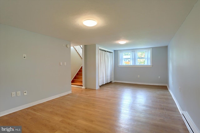 1507 Hemlock Ave, Carlisle, PA 17013 - unfurnished room featuring baseboard heating, stairway, light wood-type flooring, and baseboards