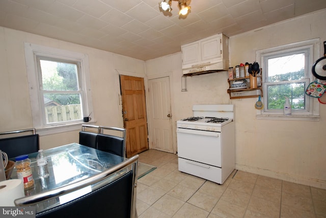 33 Adeline St, Trenton, NJ 08611 - kitchen with white gas range oven, custom exhaust hood, white cabinets, light tile patterned flooring, and baseboards