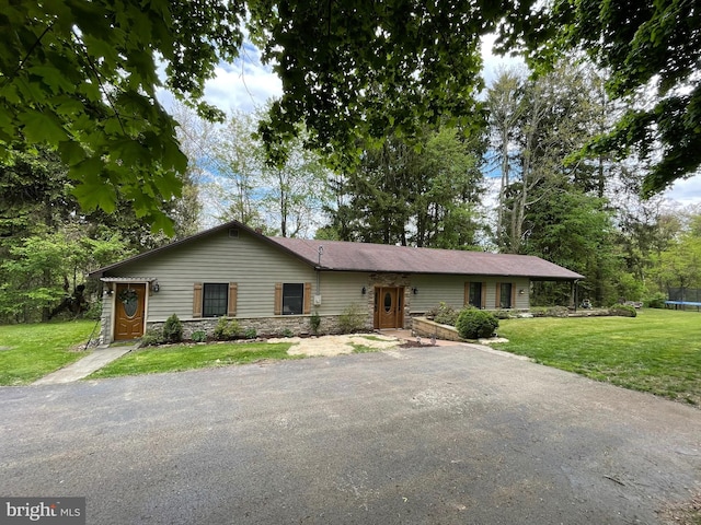 4306 National Pike, Markleysburg, PA 15459 - ranch-style home featuring a trampoline, a front yard, stone siding, and driveway