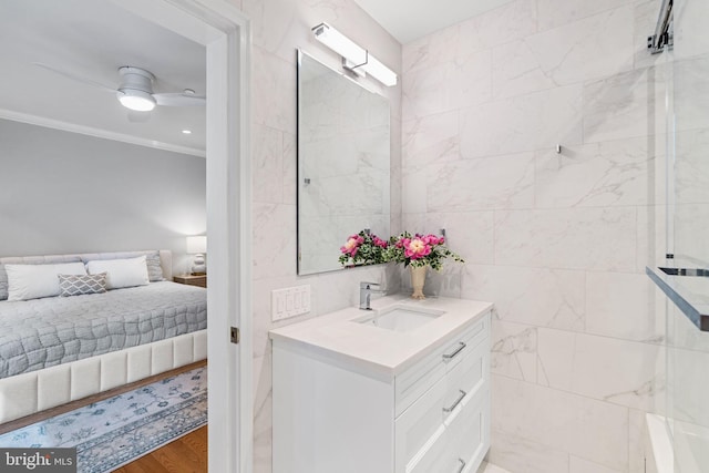 1901 Walnut St Unit 20E, Philadelphia, PA 19103 - ensuite bathroom with ornamental molding, vanity, a ceiling fan, tile walls, and wood finished floors