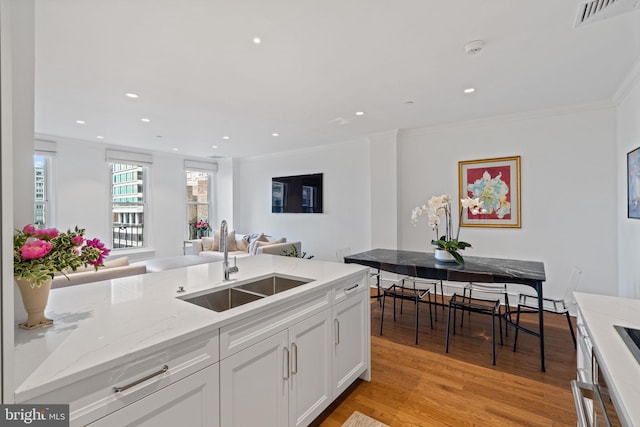1901 Walnut St Unit 20E, Philadelphia, PA 19103 - kitchen with a sink, open floor plan, ornamental molding, white cabinets, and light stone countertops