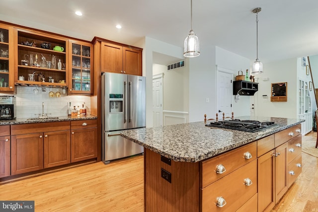 4510 Fish Hawk Ct, Chesapeake Beach, MD 20732 - kitchen with high quality fridge, light wood-style flooring, gas stovetop, brown cabinets, and stone countertops