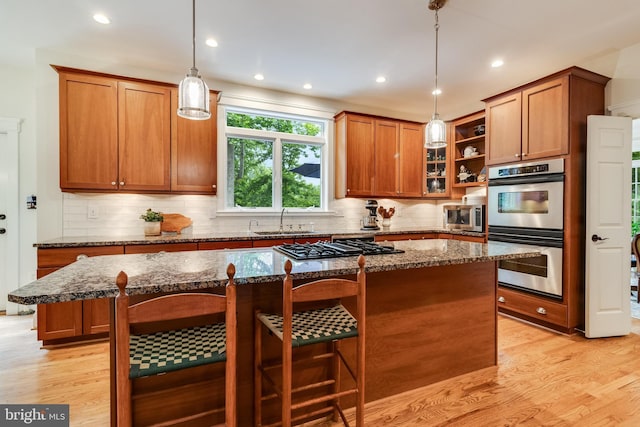 4510 Fish Hawk Ct, Chesapeake Beach, MD 20732 - kitchen with appliances with stainless steel finishes, a kitchen island, dark stone countertops, brown cabinets, and recessed lighting