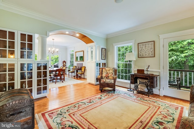 4510 Fish Hawk Ct, Chesapeake Beach, MD 20732 - sitting room with a chandelier, ornate columns, ornamental molding, wood finished floors, and arched walkways