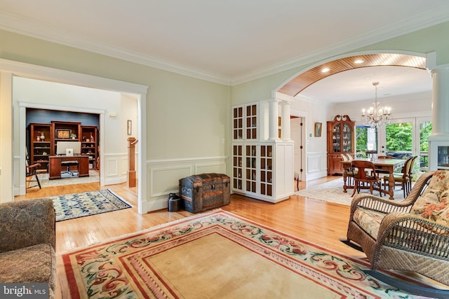 4510 Fish Hawk Ct, Chesapeake Beach, MD 20732 - living room with arched walkways, decorative columns, wood finished floors, a chandelier, and ornamental molding