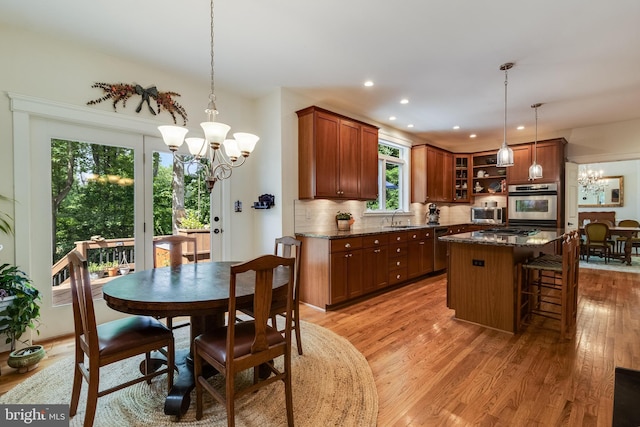 4510 Fish Hawk Ct, Chesapeake Beach, MD 20732 - kitchen with a chandelier, a breakfast bar area, light wood-style floors, decorative backsplash, and a kitchen island