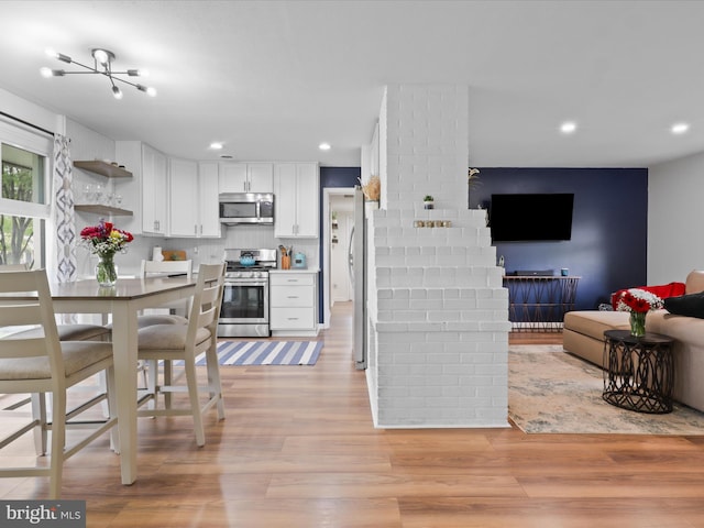 5902 Amelia St, Springfield, VA 22150 - kitchen featuring appliances with stainless steel finishes, light wood-style flooring, white cabinetry, backsplash, and open floor plan