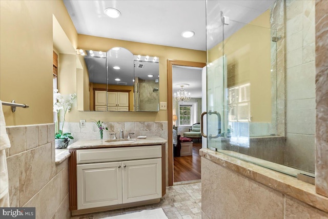 716 Old Gulph Rd, Bryn Mawr, PA 19010 - ensuite bathroom with tile walls, an enclosed shower, vanity, wainscoting, and a chandelier