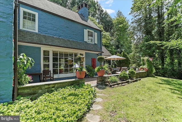716 Old Gulph Rd, Bryn Mawr, PA 19010 - rear view of property with a high end roof, a yard, stucco siding, a chimney, and a patio