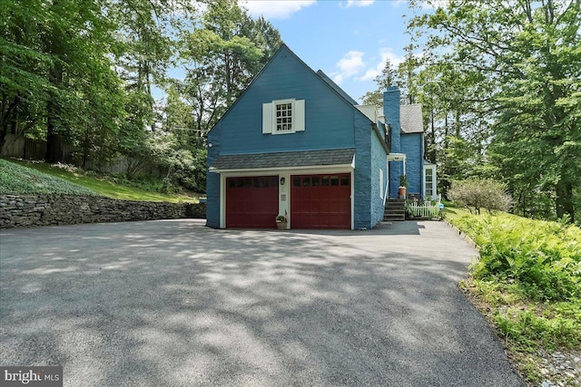 716 Old Gulph Rd, Bryn Mawr, PA 19010 - view of side of home featuring a chimney, asphalt driveway, and a garage